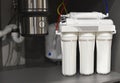House water filtration system. Osmosis deionization system. Installation of water purification filters under kitchen sink in Royalty Free Stock Photo