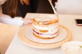 House wife wearing apron making finishing touches on birthday dessert chocolate cake.Woman making homemade cake with