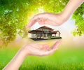 House on woman hand over Green leaf Royalty Free Stock Photo