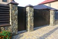 House wooden fence with wild stone column and wooden garage door