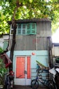 House with wooden window overshadow by big Terminalia catappa tree Royalty Free Stock Photo