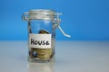 House word on piggy Bank, money box, money jar with coins