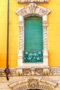 House with yellow wall. Window with green shutter.ke Royalty Free Stock Photo