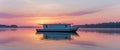 A houseboat floating on calm waters at sunset. Royalty Free Stock Photo