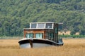 Houseboat in rushy shallow waters of bay