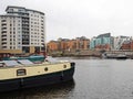 Houseboats moored on the at leeds dock with surrounding apartment buildings and knights bridge