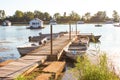 Houseboats in pond on Lake Erie from dock with rowboats tied up to access them at golden hour on a summer day