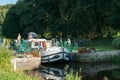 Houseboats with tourists pass through river locks on the river Oust near Josselin in Brittany