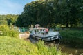 Houseboats with tourists pass through river locks on the river Oust near Josselin in Brittany