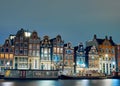 Housebots and old buildings by the canal at night in Amsterdam Royalty Free Stock Photo