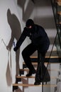 Burglar creeping on stairs