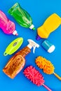 Housecleaner tools set with detergents, soap, cleaners and brush on blue background top view mock up