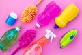 Housecleaner tools set with detergents, soap, cleaners and brush on pink background top view mock up