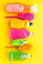 Housecleaner tools set with detergents, soap, cleaners and brush on yellow background top view mock up