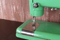 Household appliances - Fragment retro green sewing machine wooden background Royalty Free Stock Photo