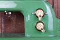 Household appliances - Front view Fragment retro green sewing machine wooden background