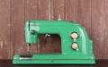 Household appliances - Front view retro green sewing machine wooden background Royalty Free Stock Photo