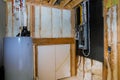 Household boiler house with heat wired electrical terminals on metal bar wall insulation in wooden house, building under