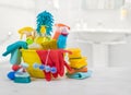 Household chemicals in bucket on table over blurred bathroom background Royalty Free Stock Photo