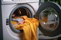 Household chore a mans hand places garments in a washer