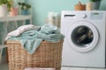 Household chores concept laundry basket beside modern washing machine in blurred background Royalty Free Stock Photo