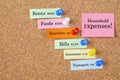 The Household expenses types on sticky note at wooden board. Budget expenses concepts