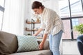 Woman arranging cushions at home