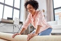 young woman unfolding carpet at home Royalty Free Stock Photo