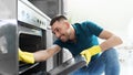 Man with rag cleaning inside oven at home kitchen Royalty Free Stock Photo