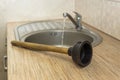 Household plumbing tool for clearing blockages is a plunger at the kitchen sink