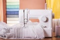 Household sewing machine with spools of thread and fabric samples in the background Royalty Free Stock Photo