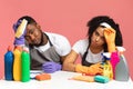 Household Stress. Exhausted couple sitting at table among detergents and cleaning tools