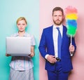 Househusband and female boss. Businessman and housewife. Family couple. Husband stand with dust brush while wife holding