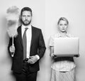 Househusband and female boss. Businessman and housewife. Family couple. Husband stand with dust brush while wife holding