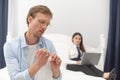 Househusband polishing his nails. Man acting feminine by polishing his nails while his wife is working with computer in Royalty Free Stock Photo