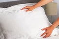 Housekeeper changing the linen and putting pillows on the bed with fresh clean white bedding. Royalty Free Stock Photo