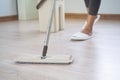 Housekeeper cleaning floor of living room by mob Royalty Free Stock Photo