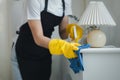 Housekeeper cleaning the furniture in the house, Wear an apron and rubber gloves to protect against cleaning chemicals, female