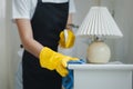 Housekeeper cleaning the furniture in the house, Wear an apron and rubber gloves to protect against cleaning chemicals, female