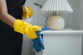 Housekeeper cleaning the furniture in the house, Wear an apron and rubber gloves to protect against cleaning chemicals, female