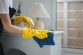 Housekeeper cleaning the furniture in the house, Wear an apron and rubber gloves to protect against cleaning chemicals, female