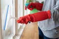 Housekeeper cleaning home concept. Woman spraying cleanser to window Royalty Free Stock Photo