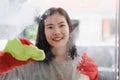 Housekeeper cleaning home concept. Woman spraying cleanser to window