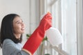 Housekeeper cleaning home concept. Woman spraying cleanser to window Royalty Free Stock Photo