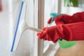 Housekeeper cleaning home concept. Woman spraying cleanser to window Royalty Free Stock Photo