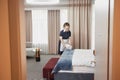 Housekeeper Cleaning Hotel Room and Setting Up Towels Royalty Free Stock Photo