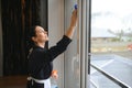 Housekeeper cleaning a hotel window Royalty Free Stock Photo