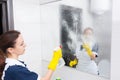 Housekeeper cleaning a wall mirror Royalty Free Stock Photo