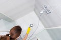 Housekeeper spraying down shower stall