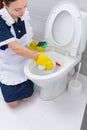 Housekeeper spraying the interior of a toilet bowl